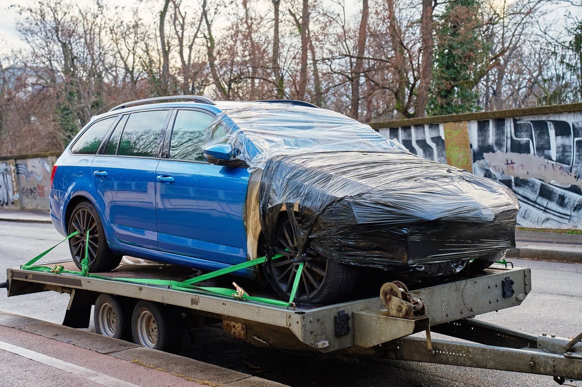 Carro apreendido sendo transportado por guincho após inadimplência no financiamento
